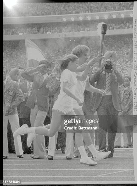 Montreal, Canada: Canadian teenagers Sandra Anderson and Stephen Prefontaine, jointly carry the Olympic Flame into Olympic Stadium, where they passed...