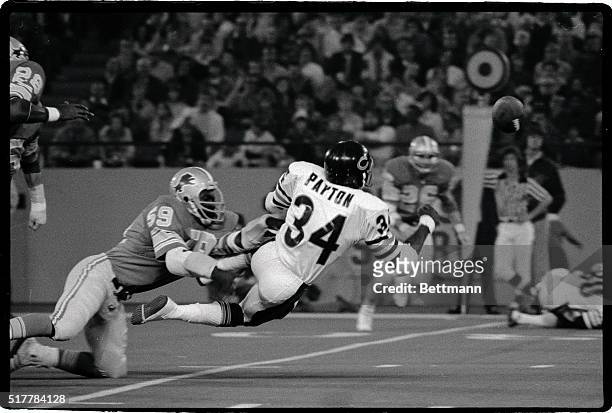 Chicago's fleet running back Walter Payton , who last week set an NFL rushing record, fumbles the ball as he is being brought down by Detroit's...