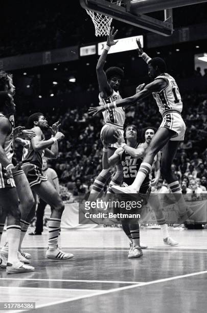New Orleans' Gail Goodrich tries to put up a shot between Philadelphia's Julius Erving and Caldwell Jones in the second period of the game here 2/8.