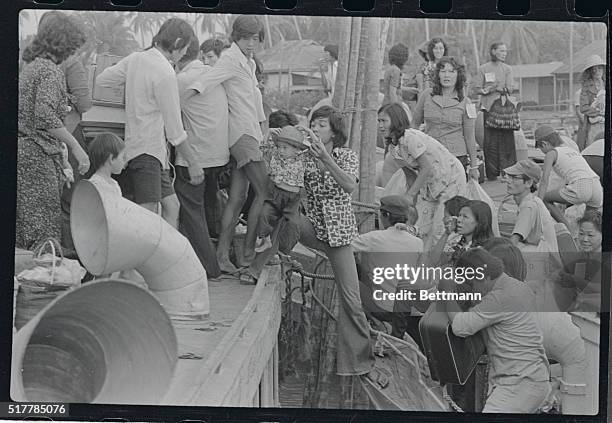 With their ID transit tags pinned to their clothing, Vietnamese refugees Pham Cong Nga , and his wife, Huynh Thi Hong Nguyet , take their belongings...