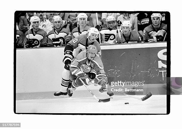 Edmonton's captain Wayne Gretzky gives a yell as he is tripped to the ice by Philadelphia's Dave Poulin as they battle for control of the puck in...