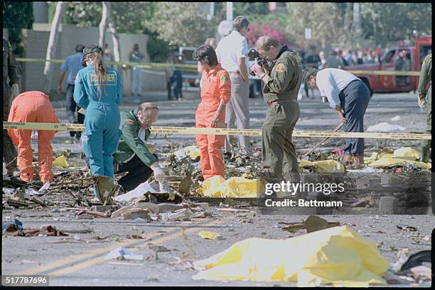 Cerritos, California: Coroners deputies sift through debris at the scene of an Aeromexico DC-9 crash 8/31. The yellow plastic covers body remains.
