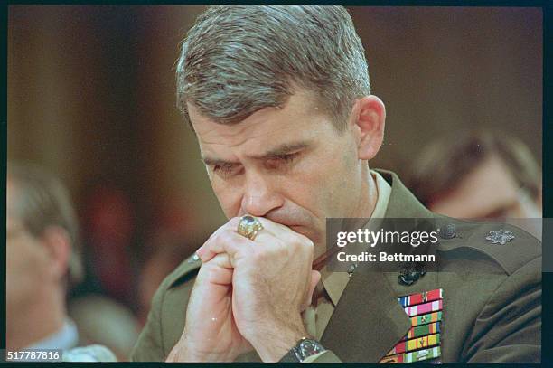 Washington: Marine Lt. Col. Oliver North listens to discussion between his attorney and committee council prior to testimony on his first day before...