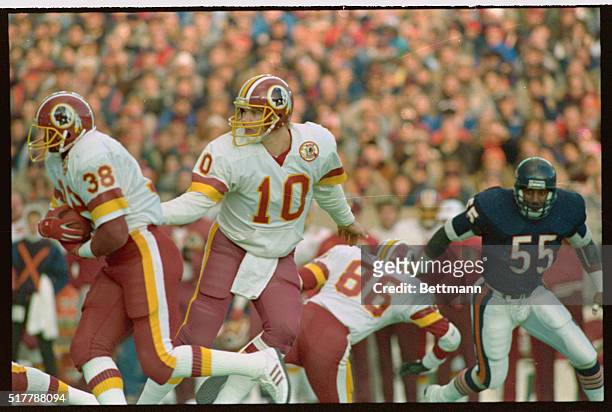 Chicago: Washington Redskins QB Jay Schroeder hands off to running back George Rogers during upset victory over the Bears, 27-13. Rogers sealed the...