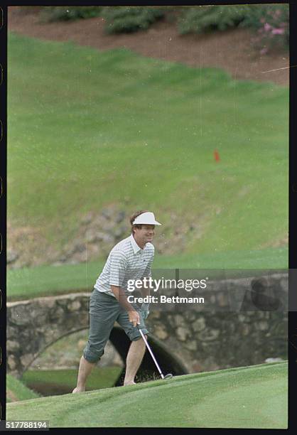 Augusta: A shoeless Tom Watson, winner of 2 Masters, walks up the bank of Rae's Creek after wading into the creek to hit his third shot to the 13th...