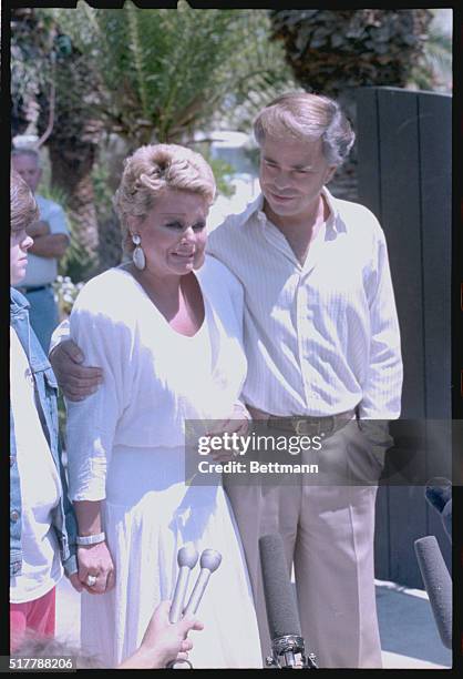 Jim and Tammy Bakker talk to reporters outside their Palm Springs mansion.