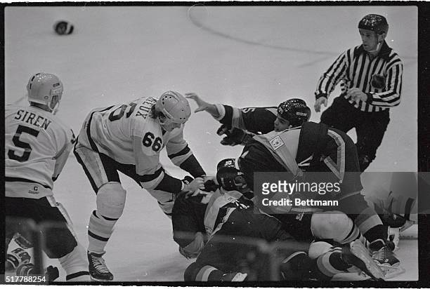 Penguin's Mario Lemieux tries to break up a fight between Canuck's Petri Striko and Penguin's Terry Ruskowski in second period of the game here....