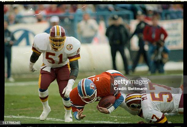 Denver quarterback John Elway drives into the end zone draging Redskins' Rich Milot with him for a second quarter Denver score in Mile High Stadium.