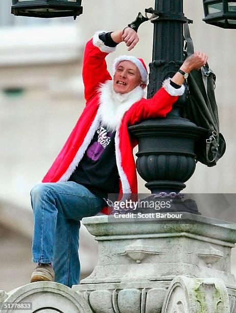 Fathers 4 Justice protestor, David Pyke dressed as Father Christmas chains himself to the top of the gates of Buckingham Palace on November 23, 2004...