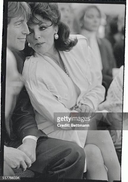 Actress Joan Collins chats at ringside with escort Bill Wiggins at the Hagler-Leonard middleweight title fight 4/6.