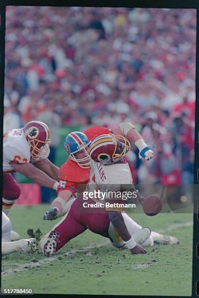 San Diego: Redskin QB Doug Williams is tripped up and helpless as Denver defensive end Rulong Jones slams into him during 1st half action in the...