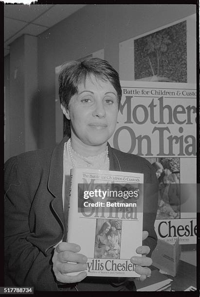 Mrs Phyllis Chesler holds up copy of her book, Mothers on Trial during a meeting of the Conference of Women Who Lost Custody of Their Children at...