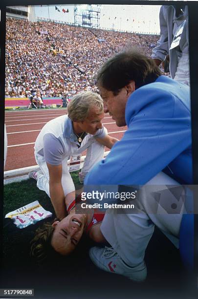 Usa's Mary Decker being helped after injuring her hip in a fall during the women's 3000m finals, which she was leading at the time. She cries in pain.