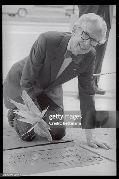 Orville Redenbacher holds the ear of popping corn which he used to write his name in cement on the Indiana Walk of Legends at the Indiana State...