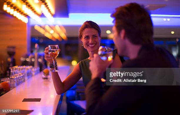 couple drinking wine in a hotel bar - flirting 個照片及圖片檔