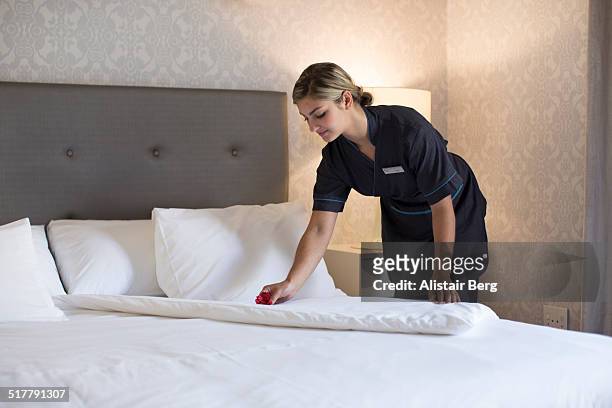 chambermaid making bed in hotel room - criada fotografías e imágenes de stock