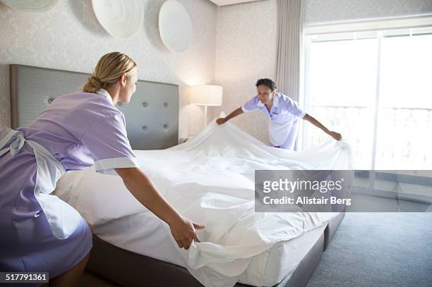 chambermaids making bed in hotel room - zimmerservice stock-fotos und bilder
