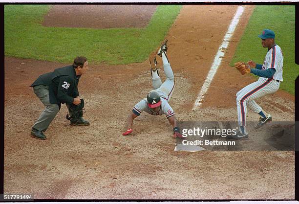 New York: Atlanta Braves Ron Gant slides home as Mets' Dwight Gooden takes a late throw from catcher Todd Hundley in third inning action at Shea...