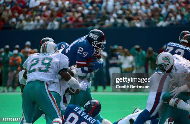 Ottis Anderson of the New York Giants dives over the one yard line for a touchdown against the Miami Dolphins defense in second quarter action at...
