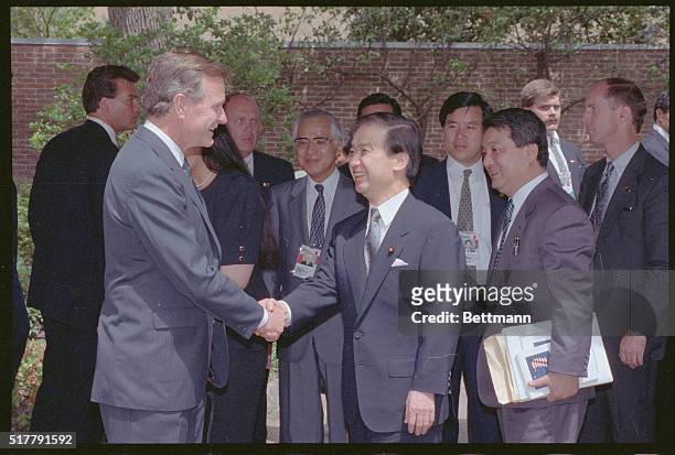 Houston: Japan's Prime Minister Toshiki Kaifu talks to a gathering outside the Houstonian Hotel while a smiling President George Bush looks on 7/7 in...