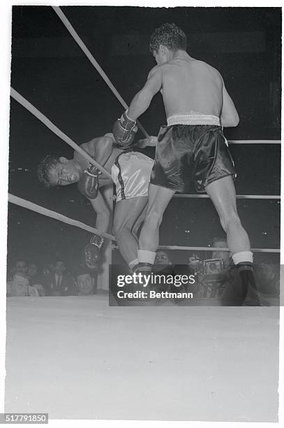 Chamrern Songkiatrat , of Thailand, hangs on the middle strand of the ropes after receiving a battering from Mexico's Raul Macias in the eighth round...