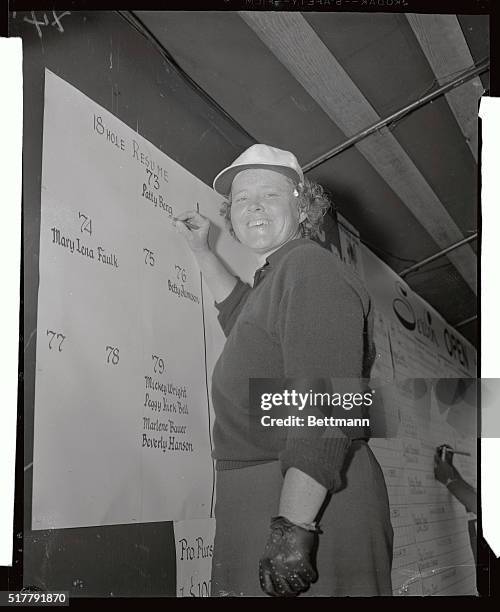 Patty Berg of St. Andrews, Ill., chalks up her score after taking the lead in the first round of the Serbin Women's Golf Tournament at the Bayshore...