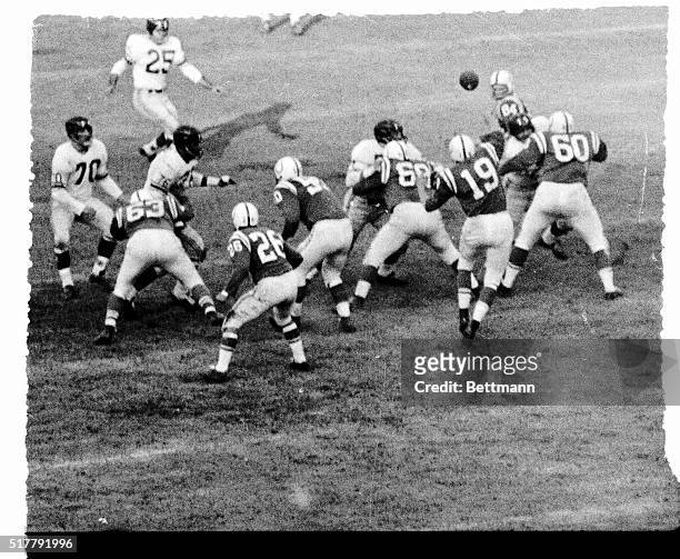 Baltimore Colts' Quarterback, Johnny Unitas , tosses a pass to End Jim Mutscheller for a first down on the Giants 25 yard line in the second quarter...