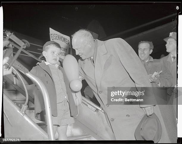 Clutching a rubber toy, Dwight David Eisenhower II gets a reassuring pat on the back from his grandfather, President-Elect Dwight D. Eisenhower. The...