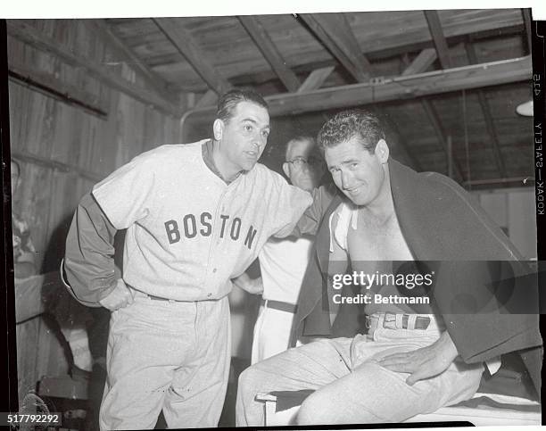 Boston Red Sox slugger Ted Williams, right, gets a consoling word or two from manager Lou Boudreau after Williams fell and fractured his shoulder...