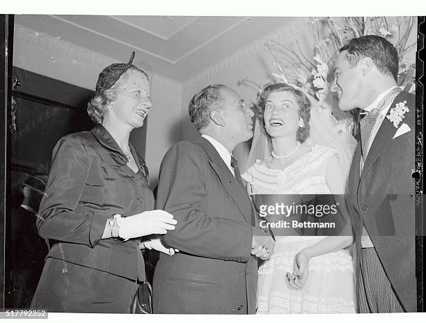 Basil G. Calevas, Greek Consul, is planting a kiss on the hand of Mrs. Robert S. Shriver, Jr., at the reception that followed her marriage at St....