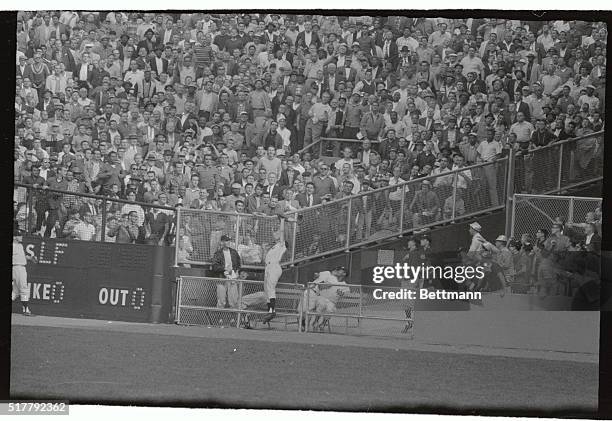 Roger Maris of the New York Yankees becomes airborne to make a spectacular catch that robbed Baltimore's Gene Woodling of a home run in the seventh...