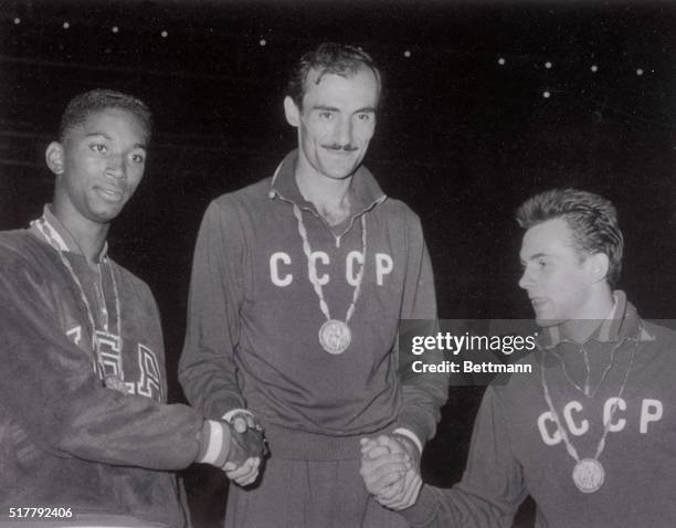 Dejected John Thomas of the United States is shown with Russia's Robert Shavlakadze and Valery Brumel , after both Russians finished ahead of him in...