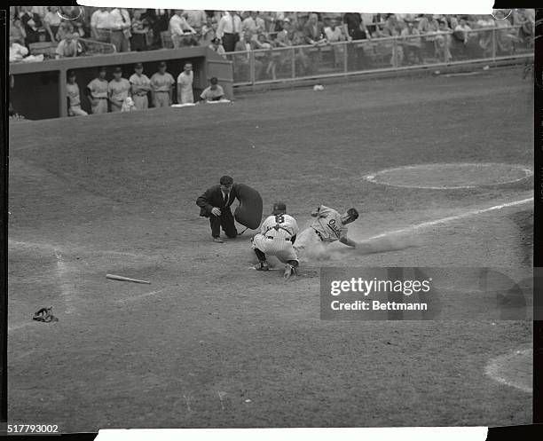 Orioles' Bob Kennedy slides home to score on Clint Courtney's center field hit in the 8th inning of the first game of a twin bill with the Yanks at...