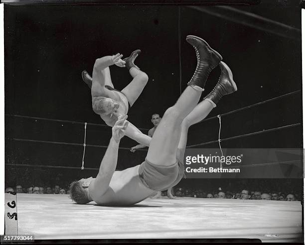 Pat O'Connor, the wrestler from down under is being tossed up and over by Hans Hermann of Boston, during their tag team match at the Garden tonight....
