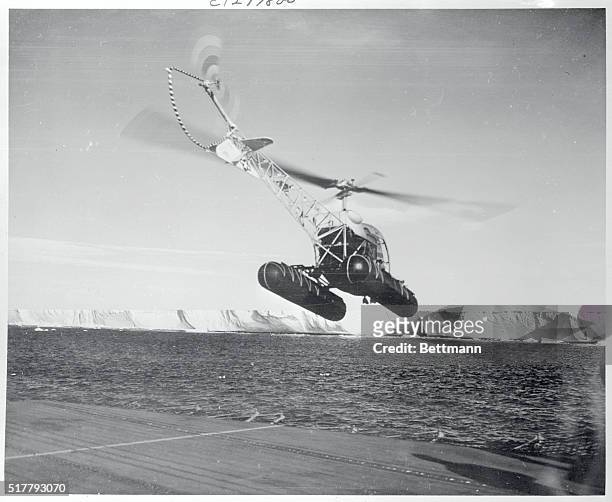 "Eggbeater" Bound for "Little America." Antarctic: Heading for Little America III, a helicopter is shown taking off from the flight deck of the...