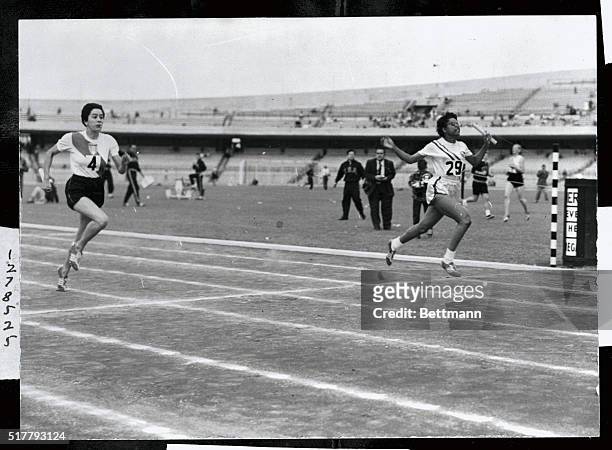 Mae Faggs of USA carries baton in women's 400 meter relays to new Pan American record of 47 seconds flat. A split second behind her is Maria Castelli...