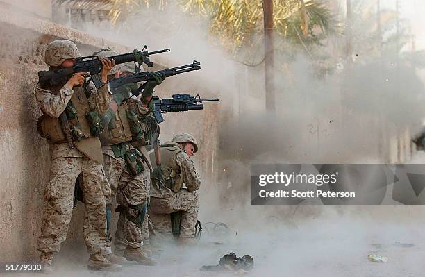 Marines of the 1st Light Armored Reconnaissance company, as part of 1st Battalion 3rd Marines, use explosives to open a metal gate to a house, as...