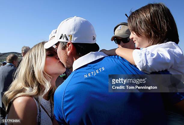 Jason Day of Australia kisses his wife Ellie as his son Dash looks on after defeating Louis Oosthuizen of South Africa 5&4 in the championship match...