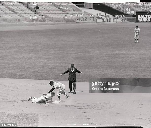 Mickey Mantle, power hitter of the New York Yankees slides safely back to second after Berra hit a single in the first inning of the game against the...
