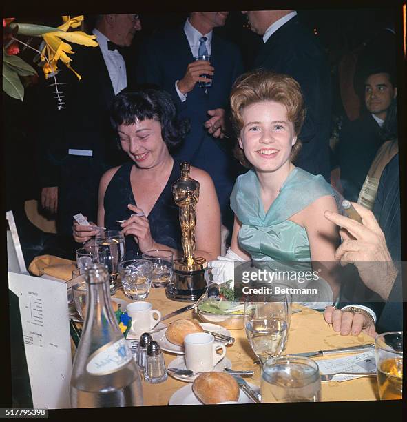 Sixteen year old Patty Duke, , smiles happily at admirers along with old timer Bette Davis after Miss Duke won the coveted Supporting Actress award...