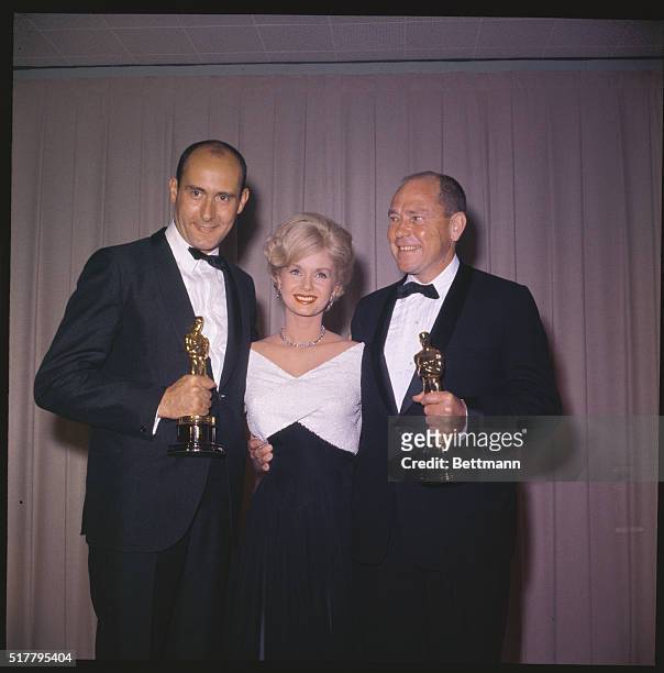 Debbie Reynolds, Henry Mancini and Johnny Mercer holding their Oscars at the Academy Awards.