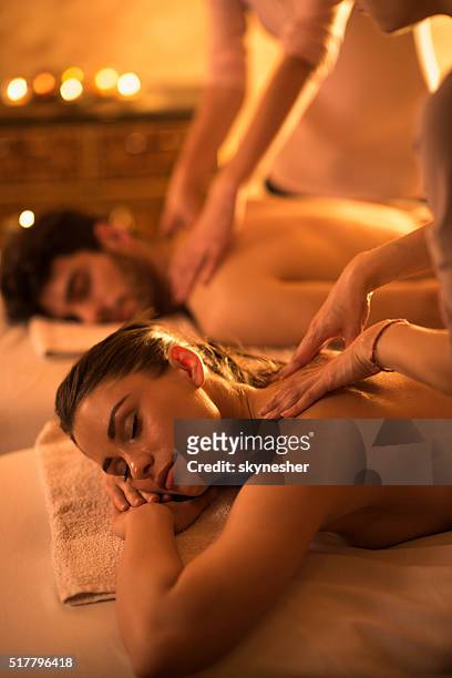 relaxed woman enjoying in back massage at the spa. - massage couple stock pictures, royalty-free photos & images