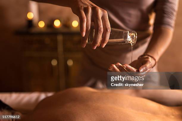close-up of massage therapist pouring massage oil in hand. - 按摩油 個照片及圖片檔