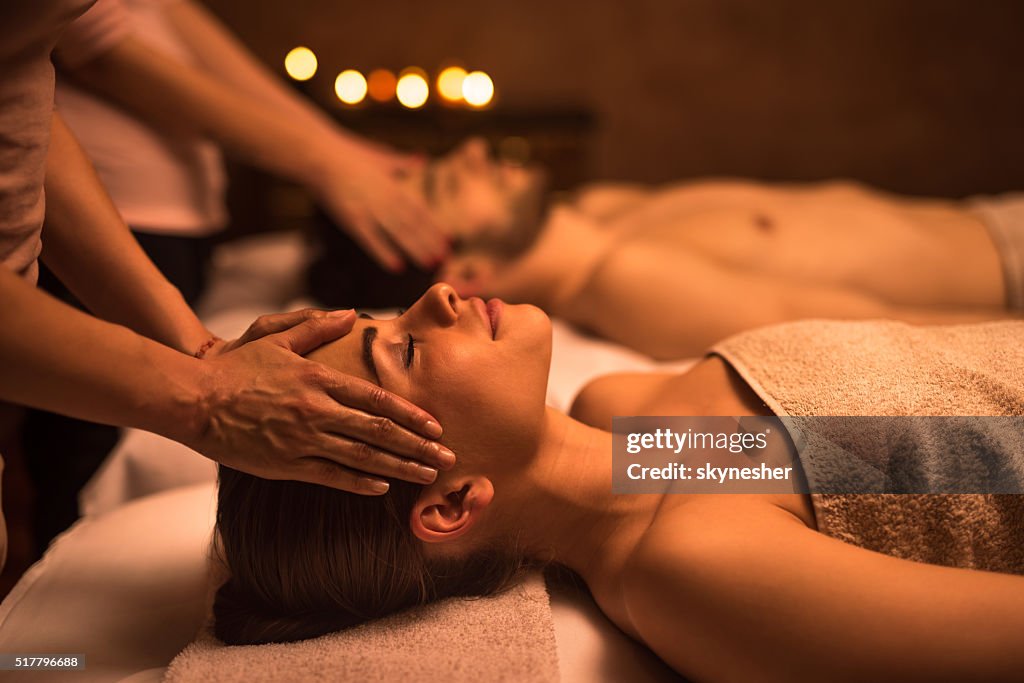 Mulher jovem no spa, desfrutando de massagem na cabeça.