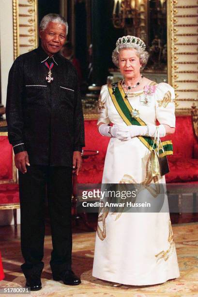 In this file photo Queen Elizabeth II poses with Nelson Mandela at Buckingham Palace on May 3, 2000 in Windsor, England.