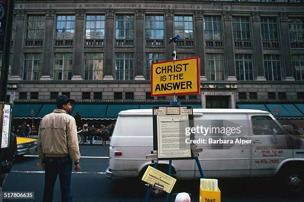 Stall with religious leaflets opposite Saks Fifth Avenue on 5th Avenue, New York City, December 1986.