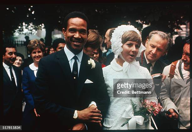 Nottingham, England: West Indian cricket star Gary Sobers and his mini-skirted bride, 26-year-old Prudence Kirby of Australia, leave registry office...