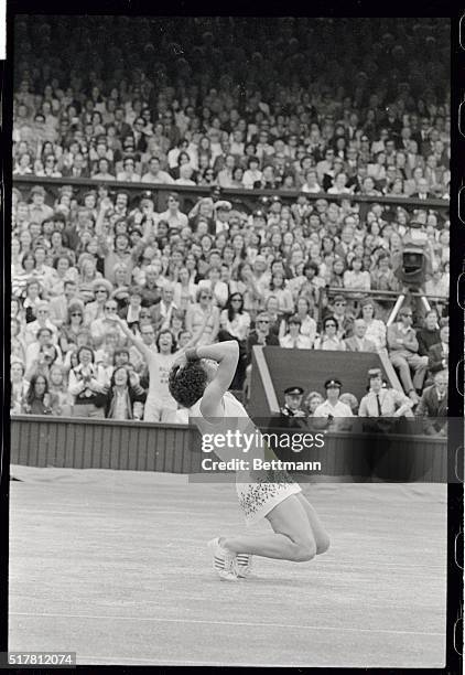 Jubilant Billie Jean King throws her arms in the air and clasps her head, while sinking to her knees, seconds after beating Evonne Goolagong, , of...