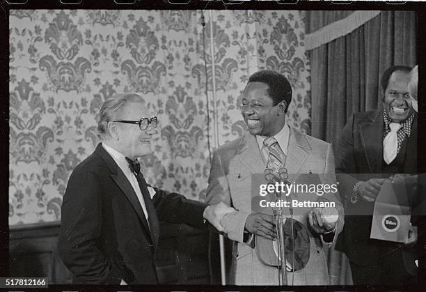 Vice President Nelson Rockefeller grabbed Milwaukee Brewers home run king, Hank Aaron, by the arm before Aaron presented three Milwaukee Brewers caps...