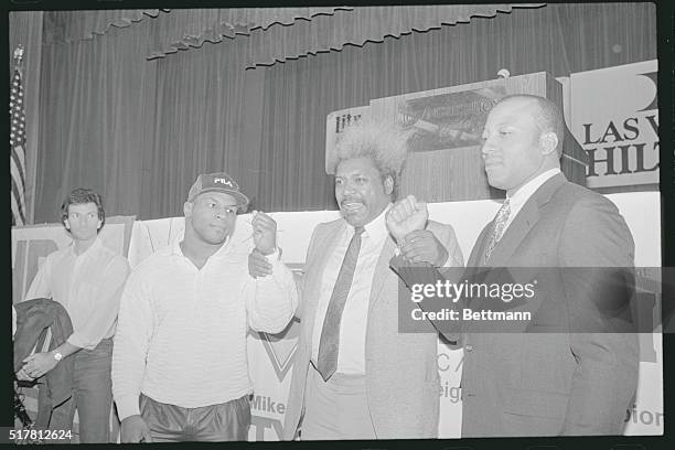 Los Angeles: Fight promoter Don King holds the arm of WBC Champion Mike Tyson and James "Bonecrusher" Smith during a news conference January 27 at...